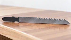 Reverse-cut jigsaw blade beside a finished wood veneer surface